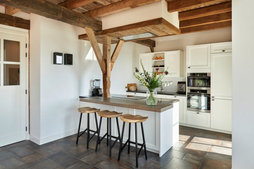 Moderne keuken met vaste bar en goed weggewerkte inbouw-apparatuur.