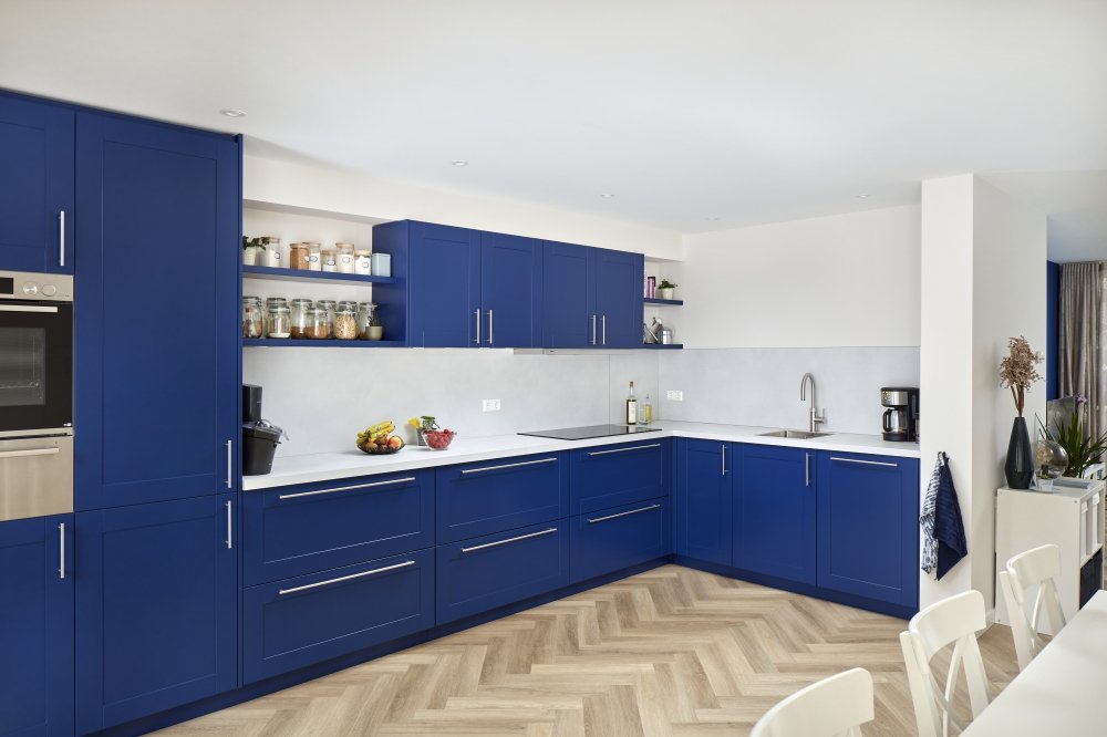 Het blauw van de keuken wordt ook gebruikt in de woonkamer.