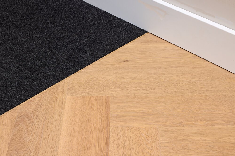 Detailfoto van de entree van de woning met de droogloopmat en de houten vloer.