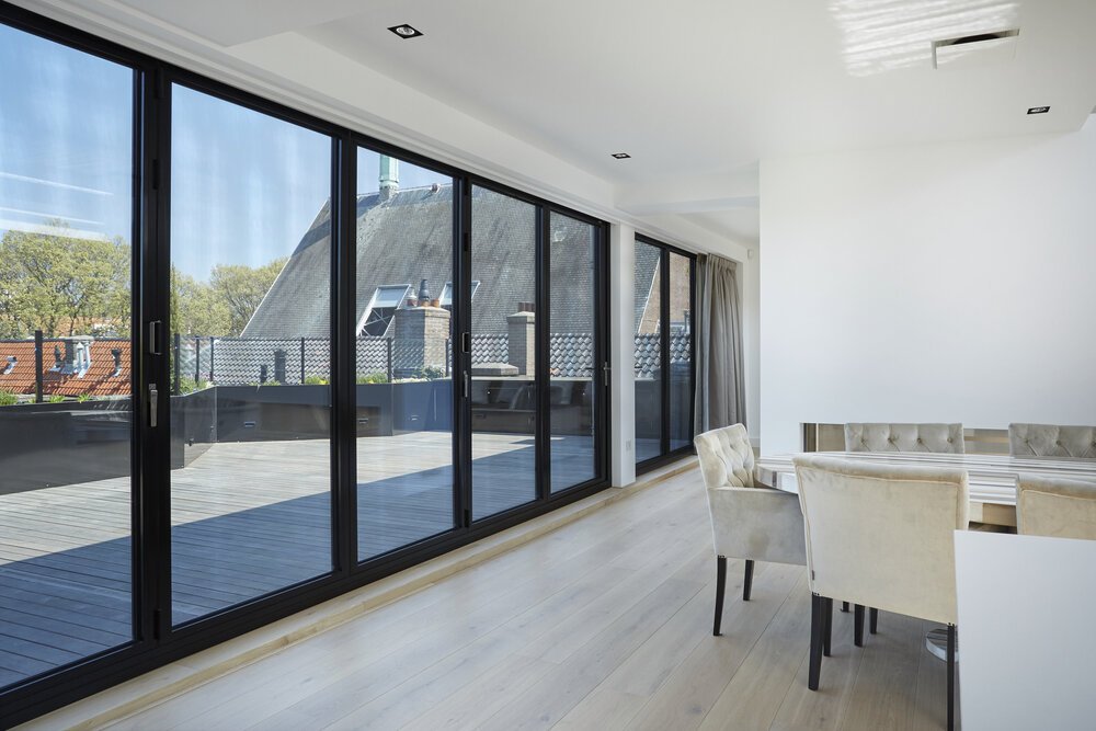 The glass folding doors create a sleek, cohesive appearance.
