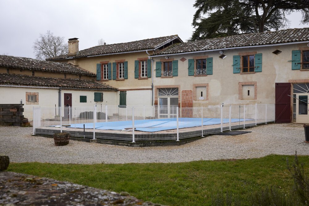 Photo of the swimming pool in the courtyard with a private area in the background.