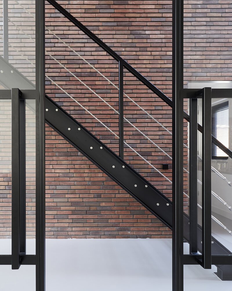 Anthracite steel sliding doors separate the living room from the glass central section.