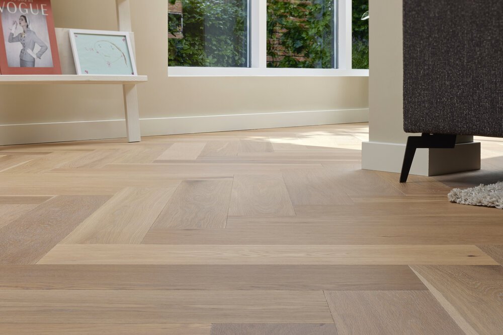 Detail shot of a herringbone floor in a living room.