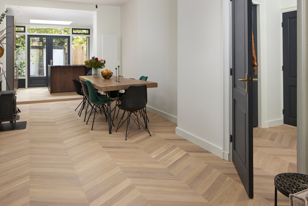 Overview image showing the extended kitchen (left in the background) and the continuous flooring at the entrance (right).