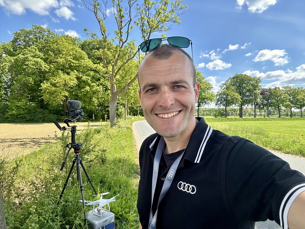 During one of the driving sessions, I selected a position where I could film the passing cars simultaneously with three cameras: one tripod placed low to the ground with a wide view in the background, a second tripod behind me on the left capturing the converging lines of the bends, and a drone filming the “train of cars” from above.