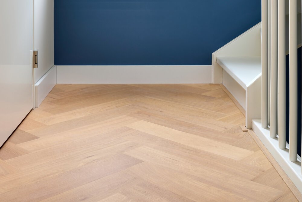 Around the corner, the herringbone floor begins: with a full run across the available space, and partial runs of the adjacent rows on each side.