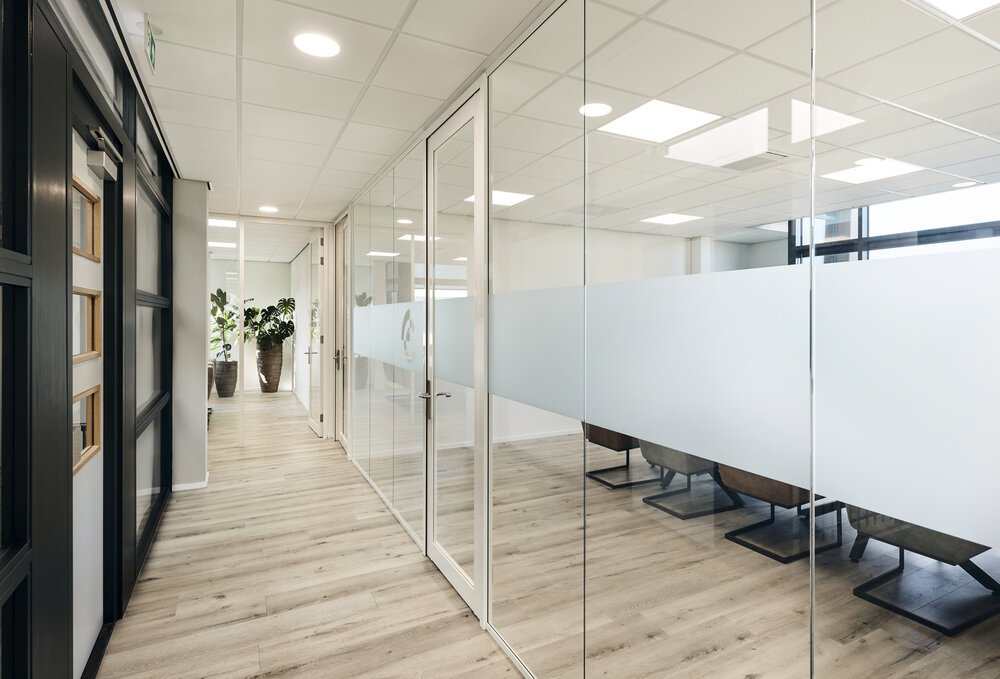 Glazen wanden verbinden werkruimtes met gangen.