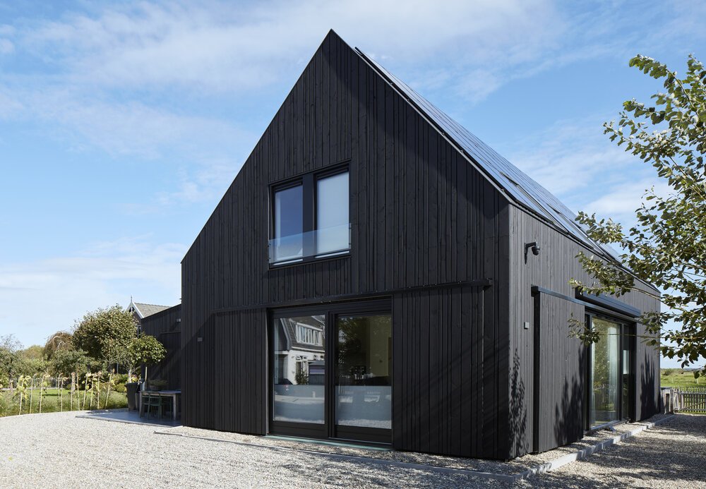 Zwarte schuurwoning tussen de boerderijen in de lintbebouwing van Vinkeveen