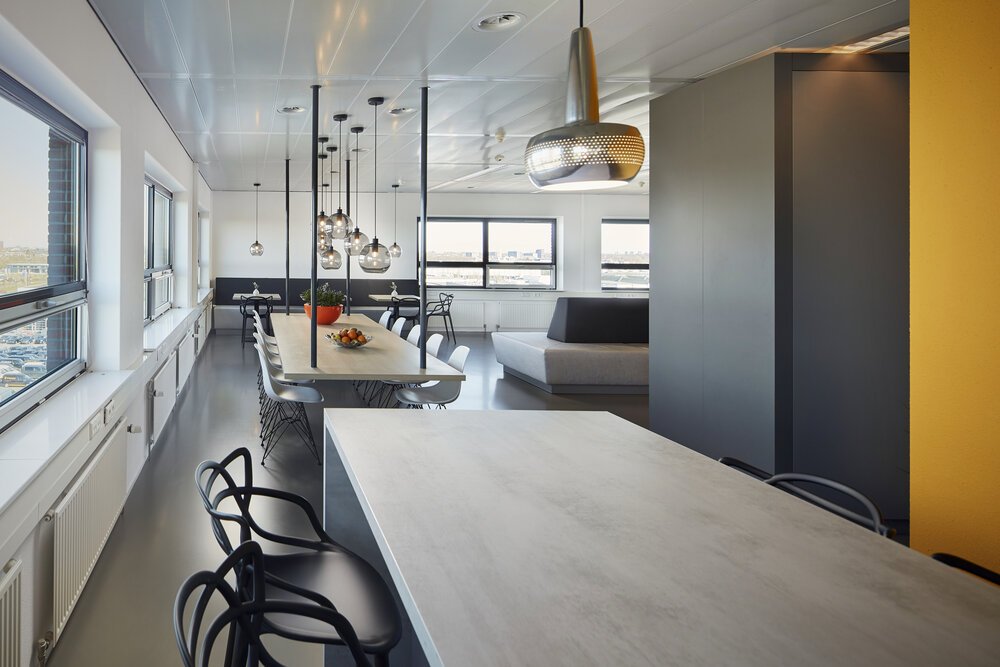 De kantine waar medewerkers kunnen eten en ontspannen met rechts de ruimte van de lockers.