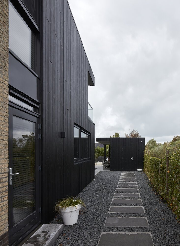 De hovenier paste het ontwerp van de tuin aan op de gebruikte materialen van de woning en schuur.