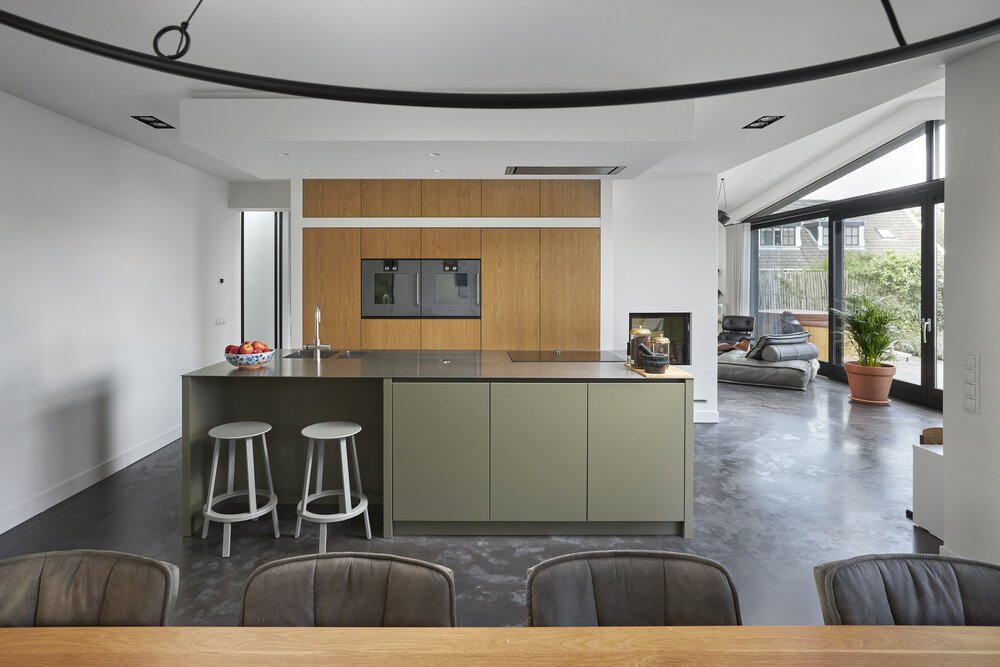 Overzichtfoto van de keuken met de eettafel op de voorgrond en woonkamer op de achtergond.