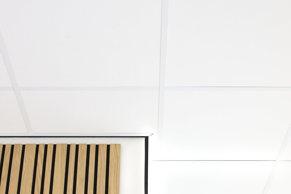 Detailfoto van systeemplafond met houten wandbekleding.