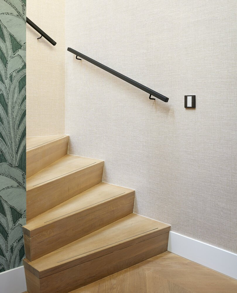 Detailfoto van de houten z-trap met stalen leuning.