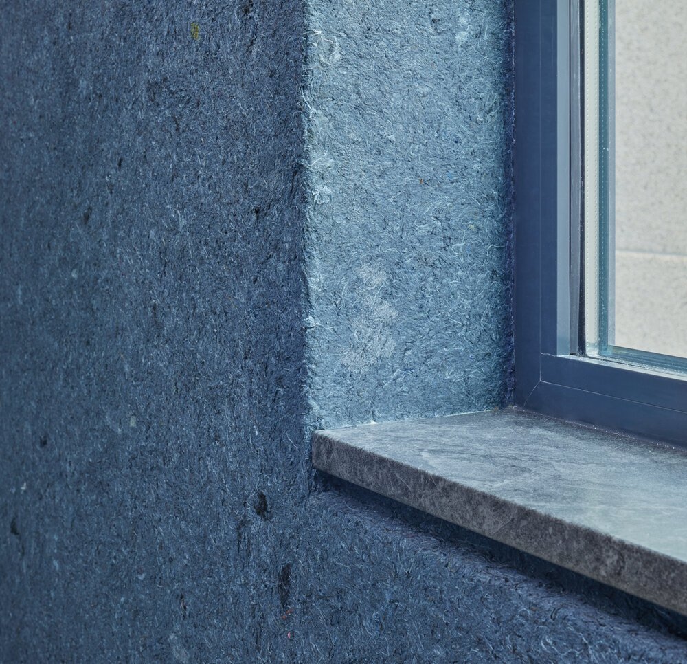 Detailfoto wandbekleding bij raamkozijn: aanbrengen van het katoen is een zware klus.