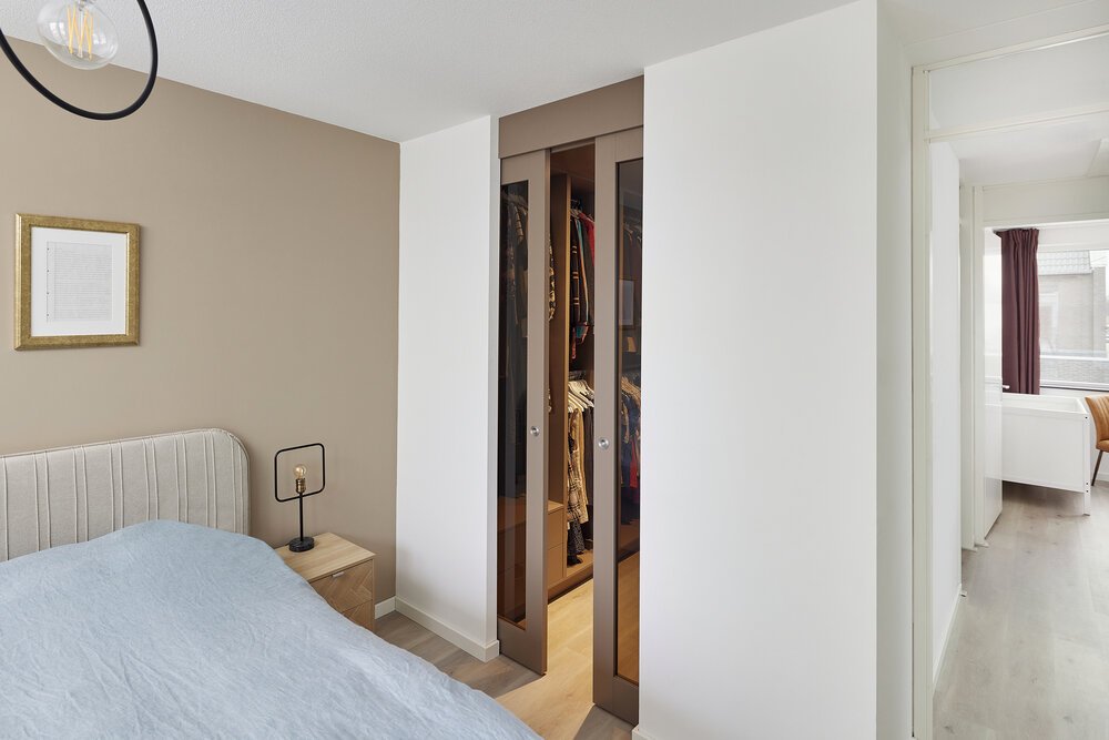 Maatwerk inloopkast valt letterlijk en figuurlijk weg in het interieur door kleur- en materiaalgebruik.