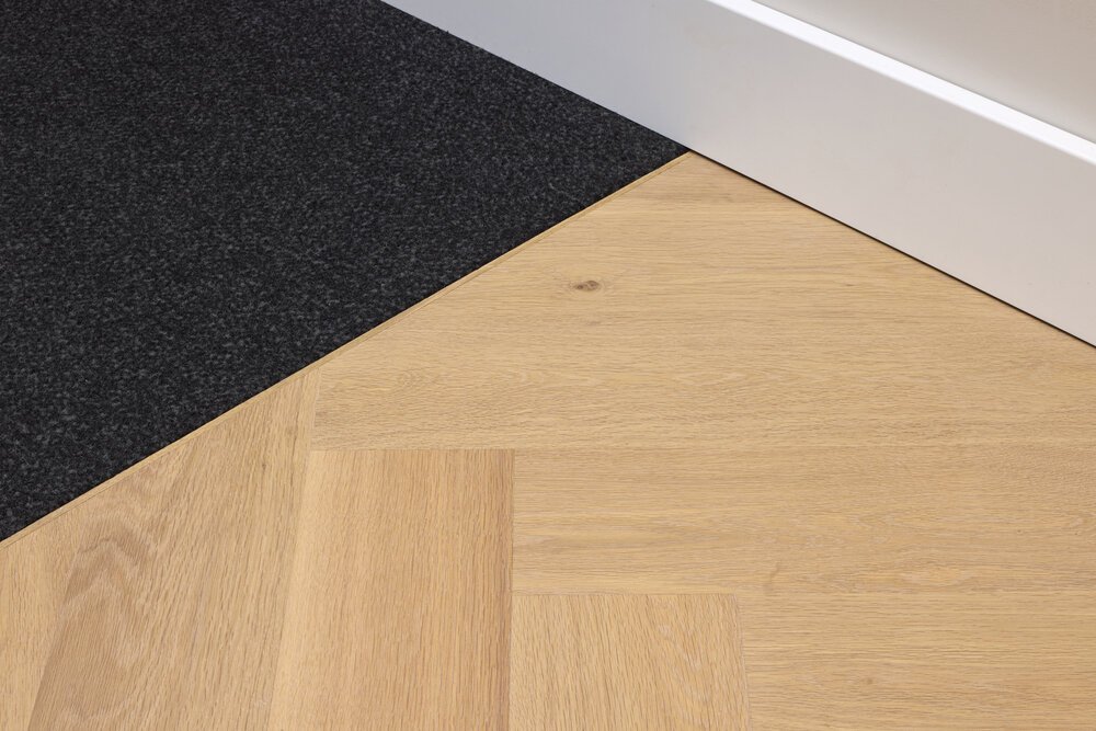 Detailfoto van de entree van de woning met de droogloopmat en de houten vloer.